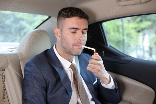 Businessman smoking in back seat © ajr_images