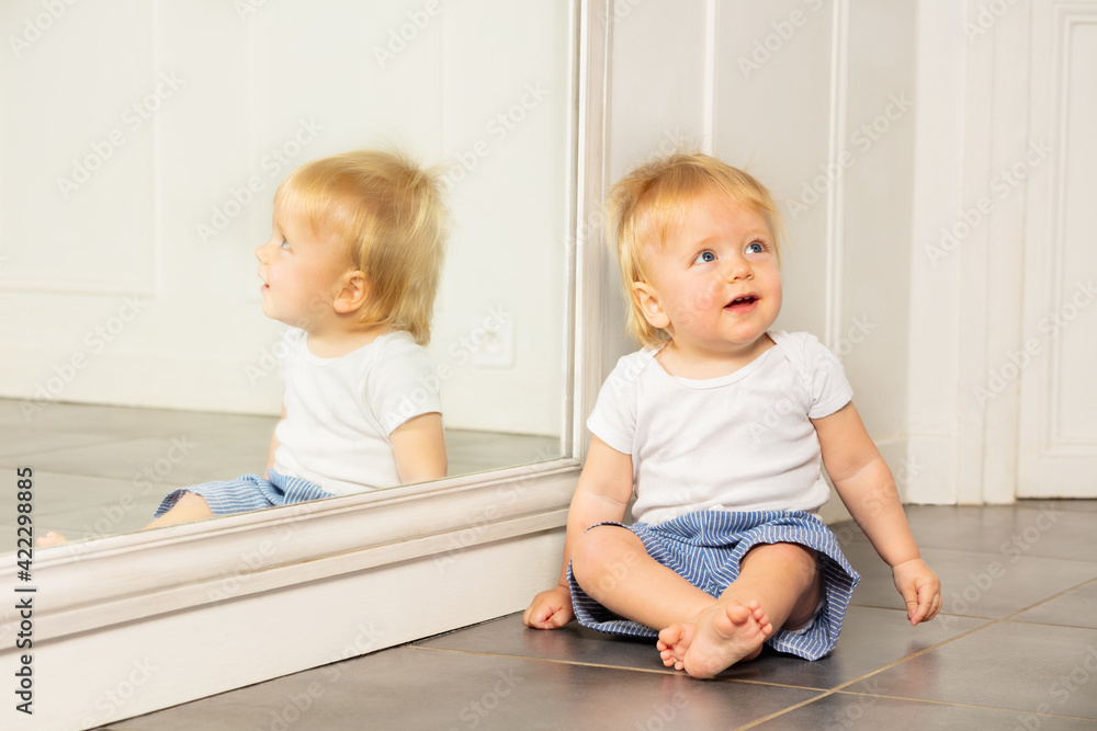 Portrait of a toddler boy sit by big mirror Portrait of a toddler boy sit by big mirror