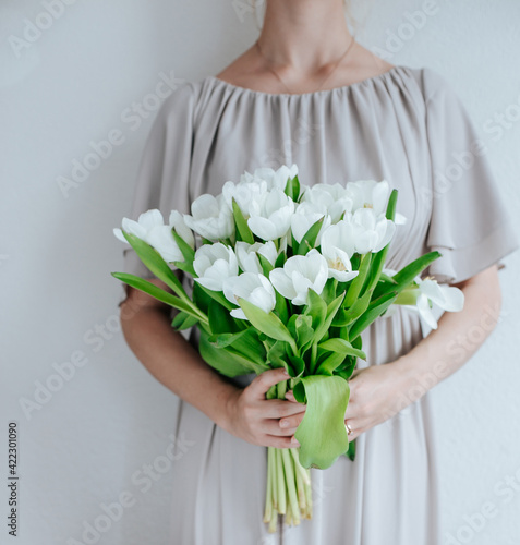 White tulips bouquet  woman holding, natural tones, with nordic vibes