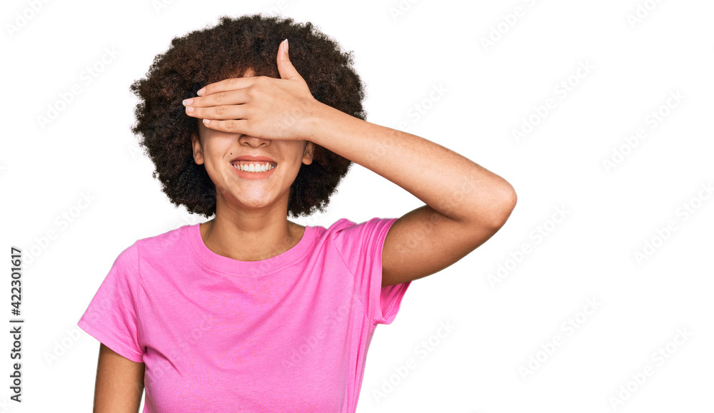 Young hispanic girl wearing casual clothes smiling and laughing with hand on face covering eyes for surprise. blind concept. Young hispanic girl wearing casual clothes smiling and laughing with hand on face covering eyes for surprise. blind concept.