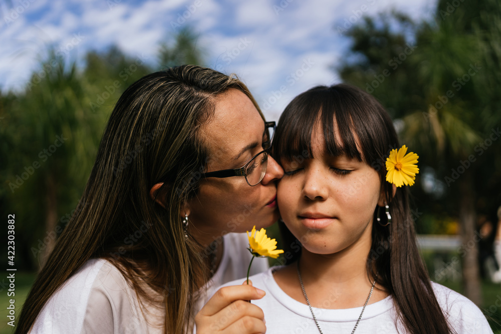 Portrait of Latina mother and daughter kissing each other. Portrait of Latina mother and daughter kissing each other.