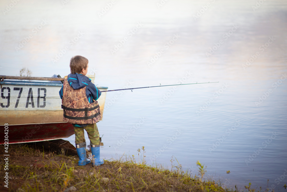 male fisherman on the riverbank with a fishing rod, Selective focus