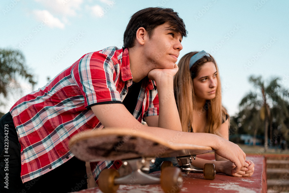 Young couple with skateboard enjoying the outdoors.