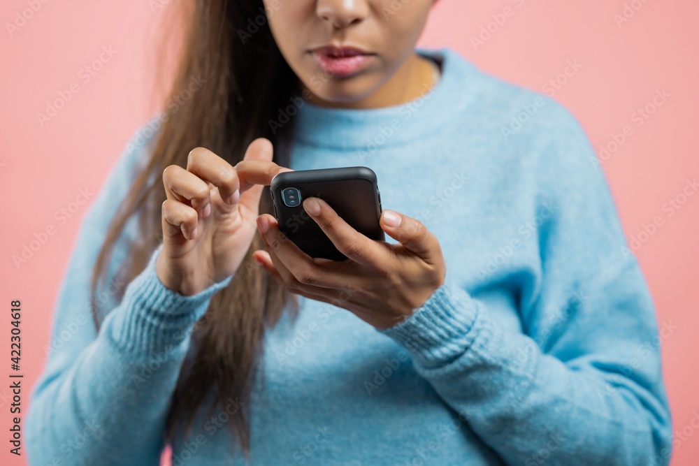 Hands of woman using smartphone on pink studio wall. Using modern technology - apps, social networks. Hands of woman using smartphone on pink studio wall. Using modern technology - apps, social networks.