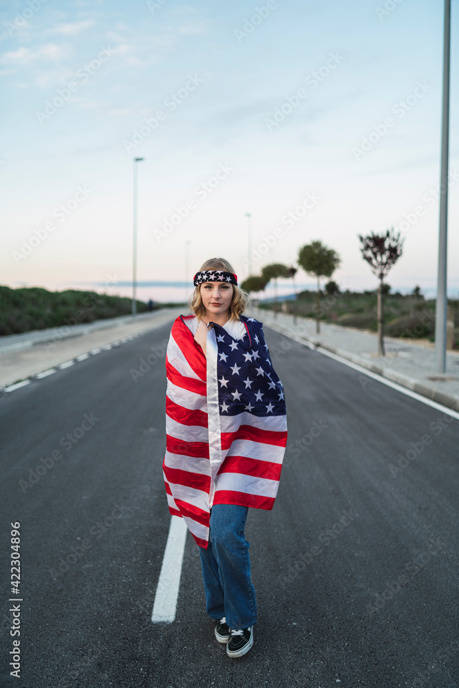 Chica joven atractiva rubia con bandera americana
