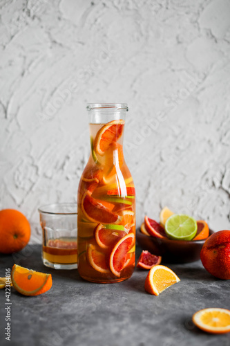 Mixed citrus lemonade in a tall glass jar. A drink made from red oranges, lemons and limes. Refreshing cold cocktails.