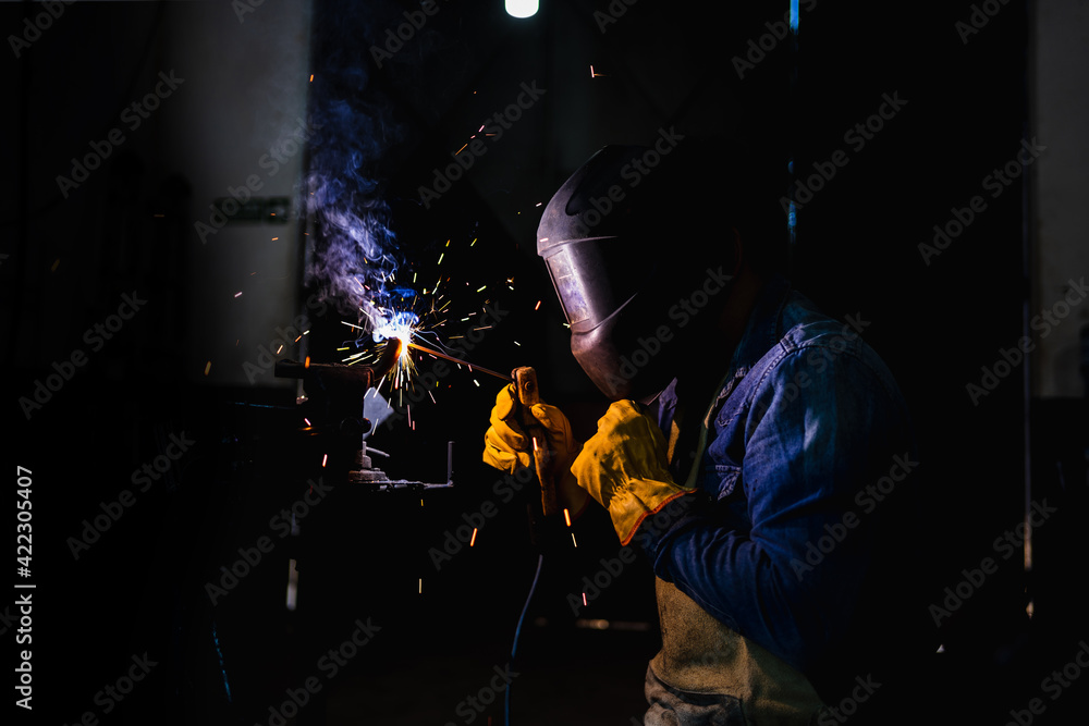 Welder working in his workshop. Concept of industry and construction. Welder working in his workshop. Concept of industry and construction.