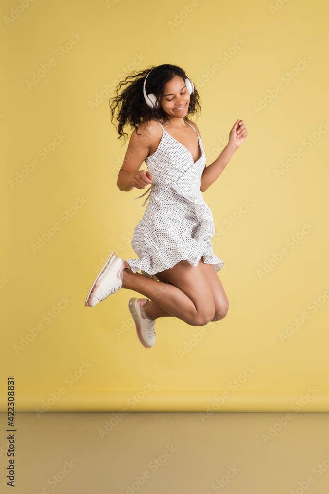 African-american woman portrait isolated on yellow studio background with copyspace
