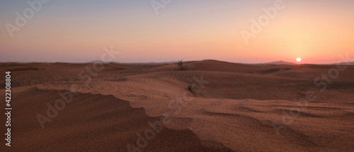 Sunset over the sand dunes in the desert.