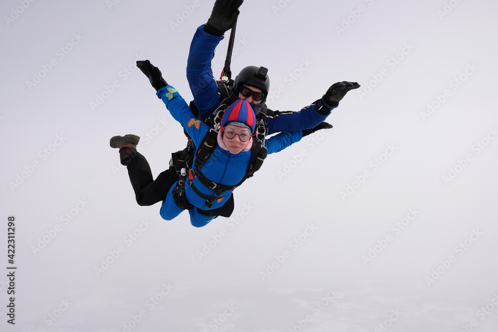 Skydiving. Tandem jump. Man and woman. Winter season. Skydiving. Tandem jump. Man and woman. Winter season.