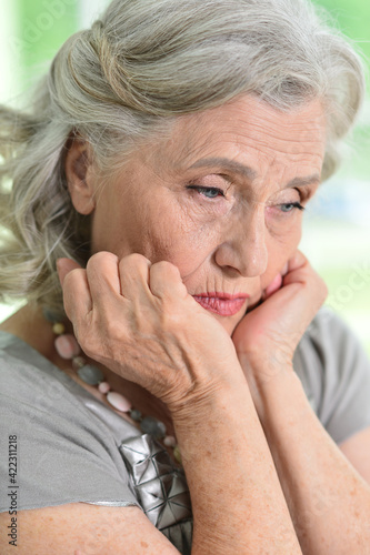 portrait of a sad old woman on a light background