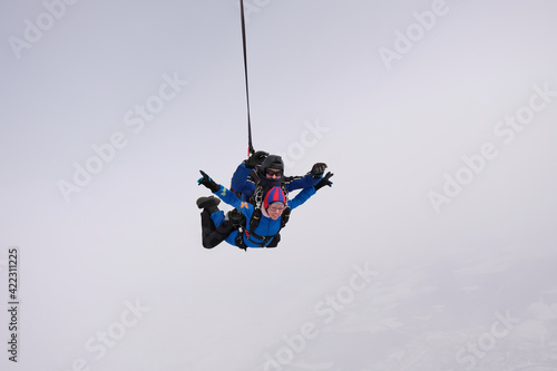 Skydiving. Tandem jump. Man and woman. Winter season.