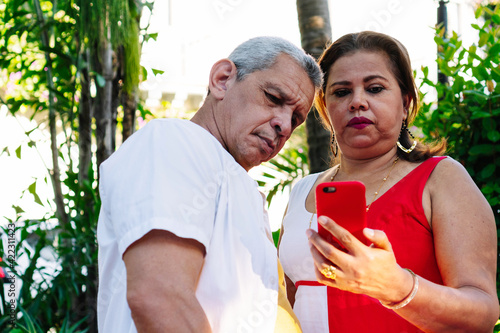 Older couple checking cell phone in park