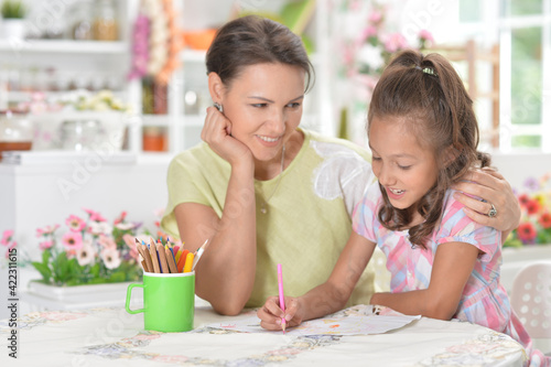 little cute girl with mother drawing  at home