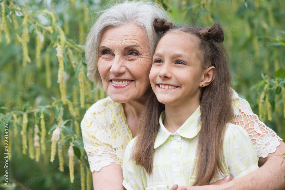portrait of a happy grandmother and granddaughter in the park