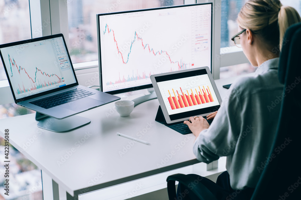 Anonymous woman analyzing diagrams on gadgets