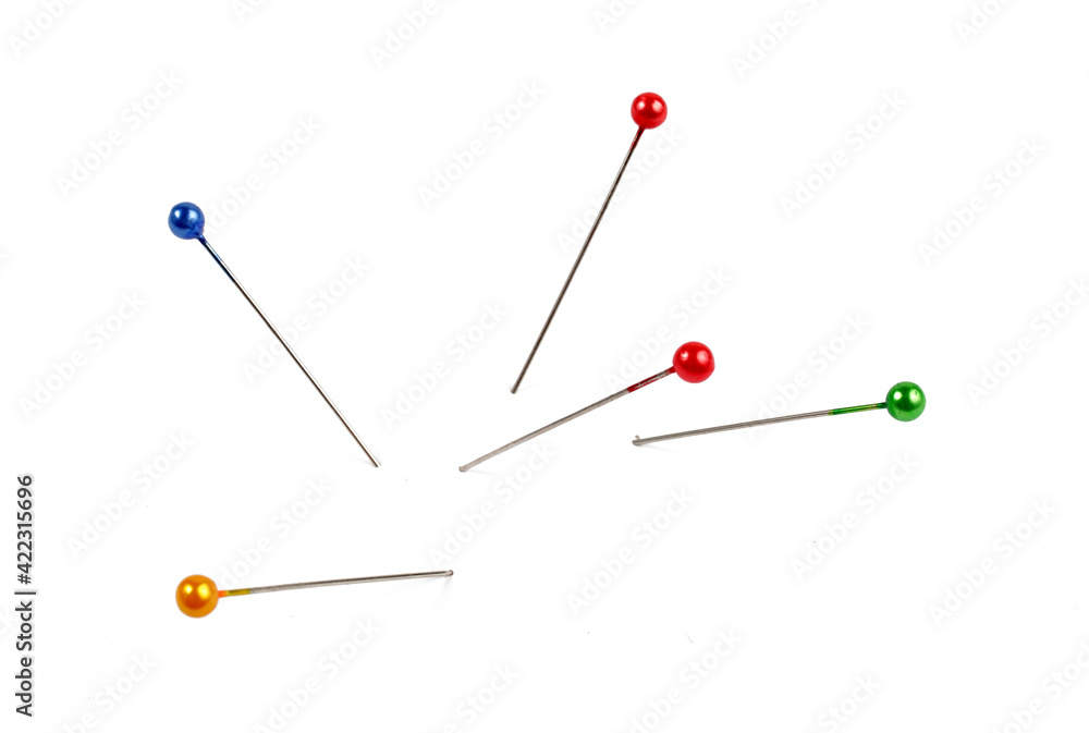 five multi-colored pins on a white background, isolate. five multi-colored pins on a white background, isolate.