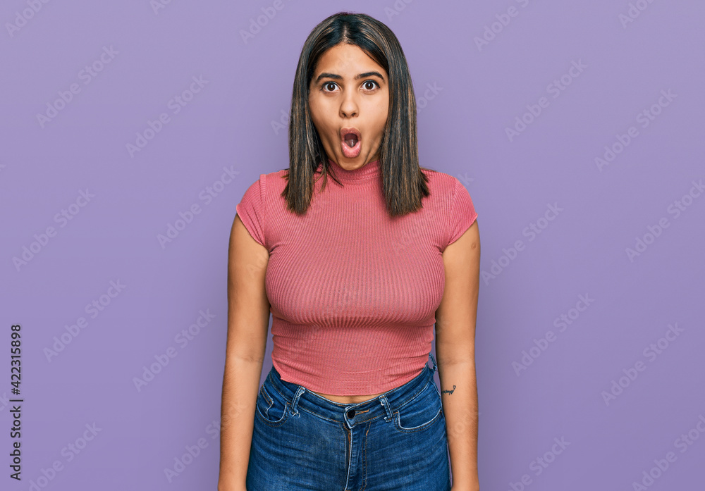 Young hispanic girl wearing casual t shirt afraid and shocked with surprise expression, fear and excited face. Young hispanic girl wearing casual t shirt afraid and shocked with surprise expression, fear and excited face.