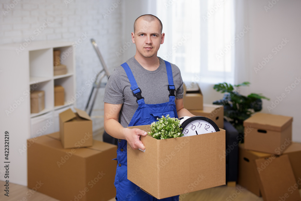 Portrait of loader in room holding a box with belongings Portrait of loader in room holding a box with belongings