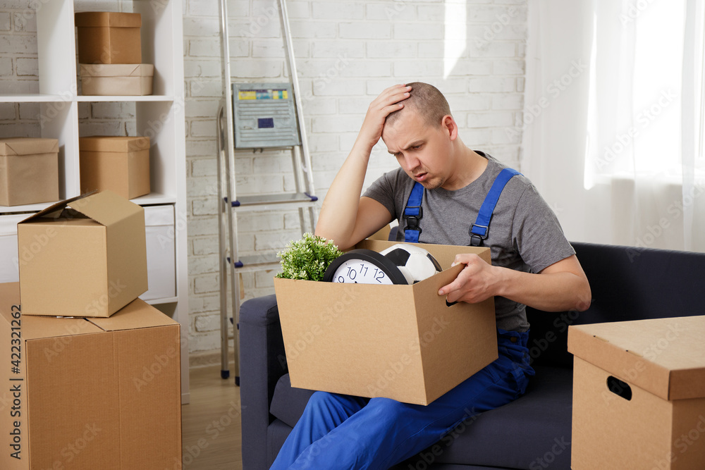 portrait of tired loader sitting on sofa in room .after moving day portrait of tired loader sitting on sofa in room .after moving day