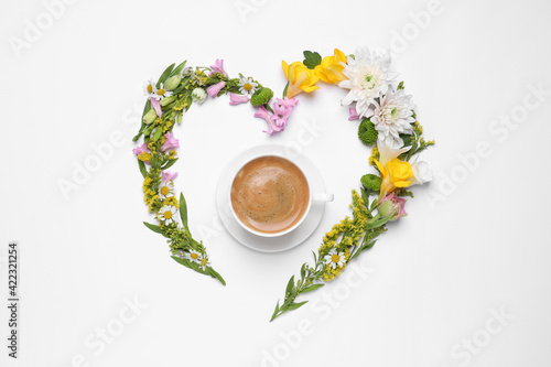 Beautiful heart made of different flowers and coffee  on white background  top view