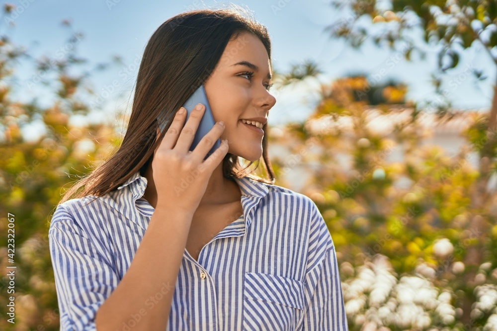 Young hispanic girl smiling happy talking on the smartphone at the city. Young hispanic girl smiling happy talking on the smartphone at the city.