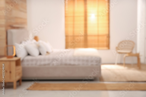 Blurred view of stylish hotel room interior with comfortable bed