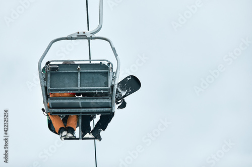 People using chairlift at mountain ski resort. Winter vacation © Georgii