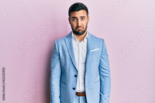 Young hispanic businessman wearing business jacket depressed and worry for distress, crying angry and afraid. sad expression.