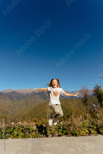Happy young girl jumping in sun