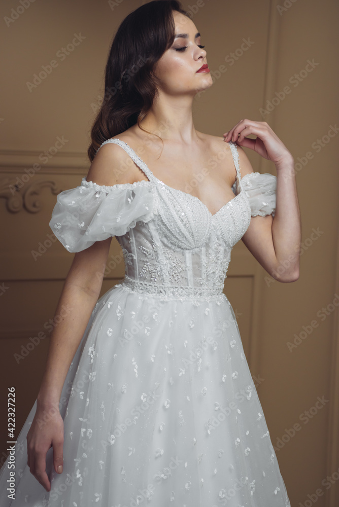 Girl bride in a white dress on a background in the studio. Girl bride in a white dress on a background in the studio.