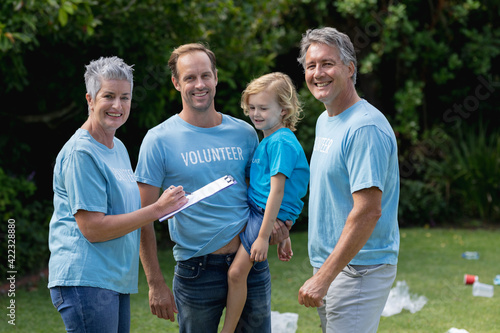 Caucasian senior couple with father and son in volunteer shirts smiling in littered field © wavebreak3