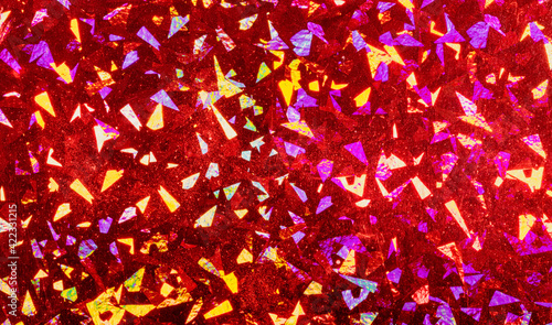 Red foil with holographic effect. Christmas background. Holographic foil refl...