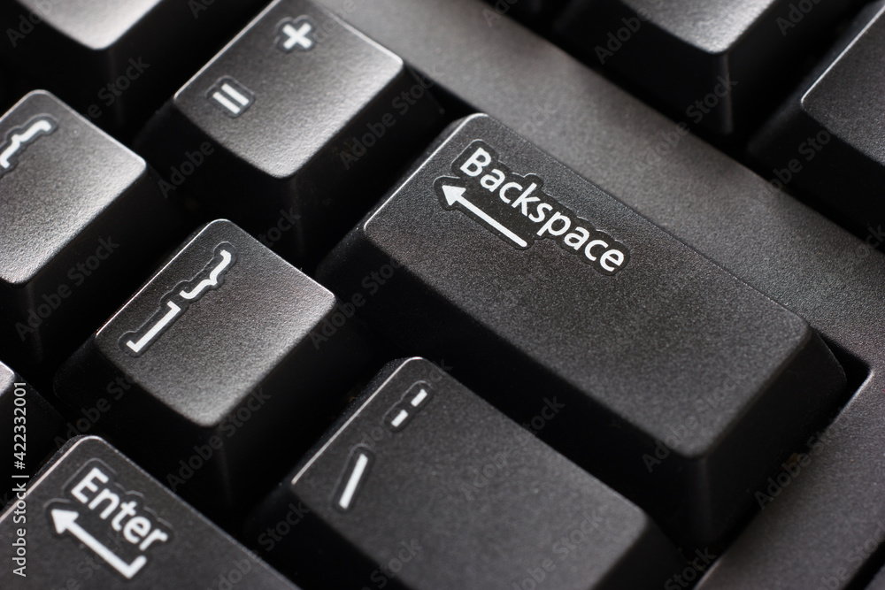 Black plastic standard English computer keyboard close up macro shot top side view backspace button Black plastic standard English computer keyboard close up macro shot top side view backspace button