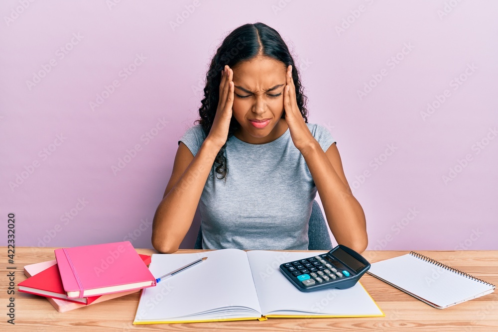 Young african american girl accountant working at the office with hand on head for pain in head because stress. suffering migraine. Young african american girl accountant working at the office with hand on head for pain in head because stress. suffering migraine.