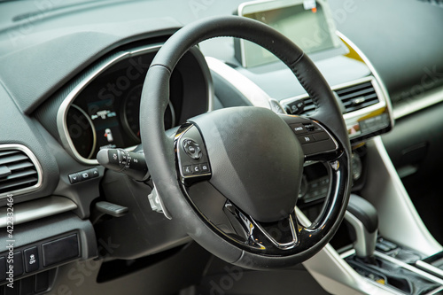 empty interior of modern premium car dark interior close-up steering wheel and drivers seat © Maria