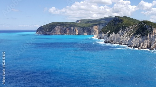 a beautiful view of the turquoise blue eonian sea crashing into the cliffs