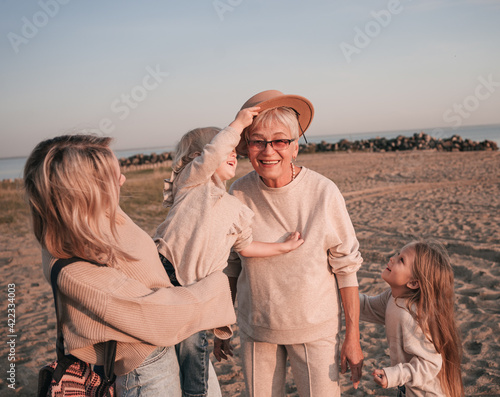 Elderly smiling woman with her daughter and grandchildren on the beach