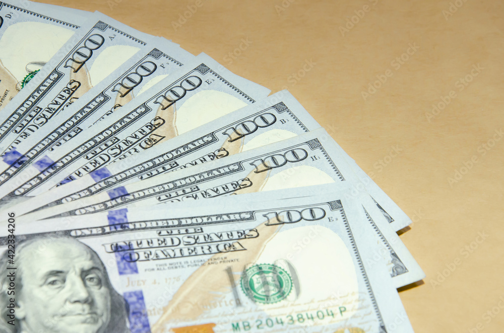 One hundred dollar bills are on table. US dollars background. American currency. Cash money for payment. Financial calculations concept. One hundred dollar bills are on table. US dollars background. American currency. Cash money for payment. Financial calculations concept.