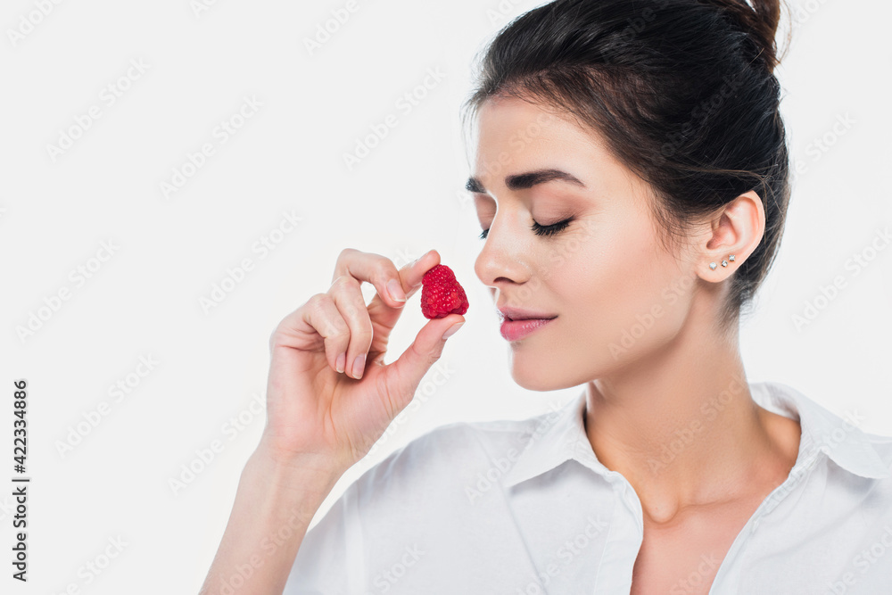 Young woman with closed eyes holding strawberry isolated on white Young woman with closed eyes holding strawberry isolated on white