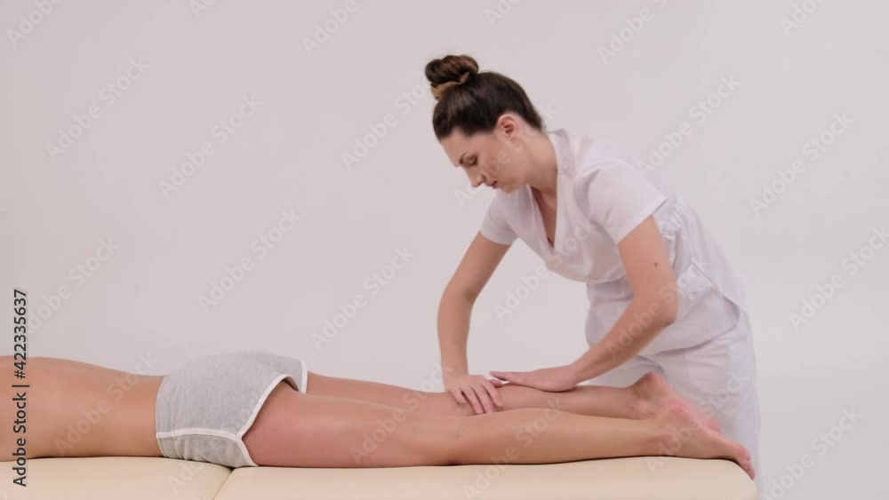 woman lying on bed in beauty salon spa. The therapist's hands are massaging the young woman's legs and foot. Spa, concept massage, aromatherapy, and skincare for women. woman lying on bed in beauty salon spa. The therapist's hands are massaging the young woman's legs and foot. Spa, concept massage, aromatherapy, and skincare for women.