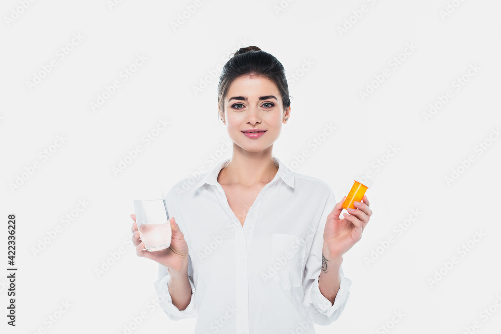 Smiling woman holding jar with pills and glass of water isolated on white Smiling woman holding jar with pills and glass of water isolated on white