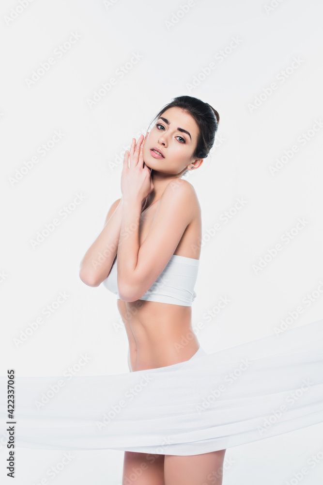 Young woman in underwear looking at camera near cloth isolated on white Young woman in underwear looking at camera near cloth isolated on white