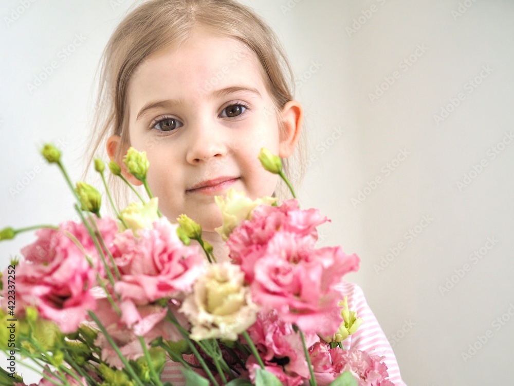 Adorable little girl holding bouquet of flowers. Cute happy child with flower bouquet. Happy Easter. Hello spring banner Adorable little girl holding bouquet of flowers. Cute happy child with flower bouquet. Happy Easter. Hello spring banner