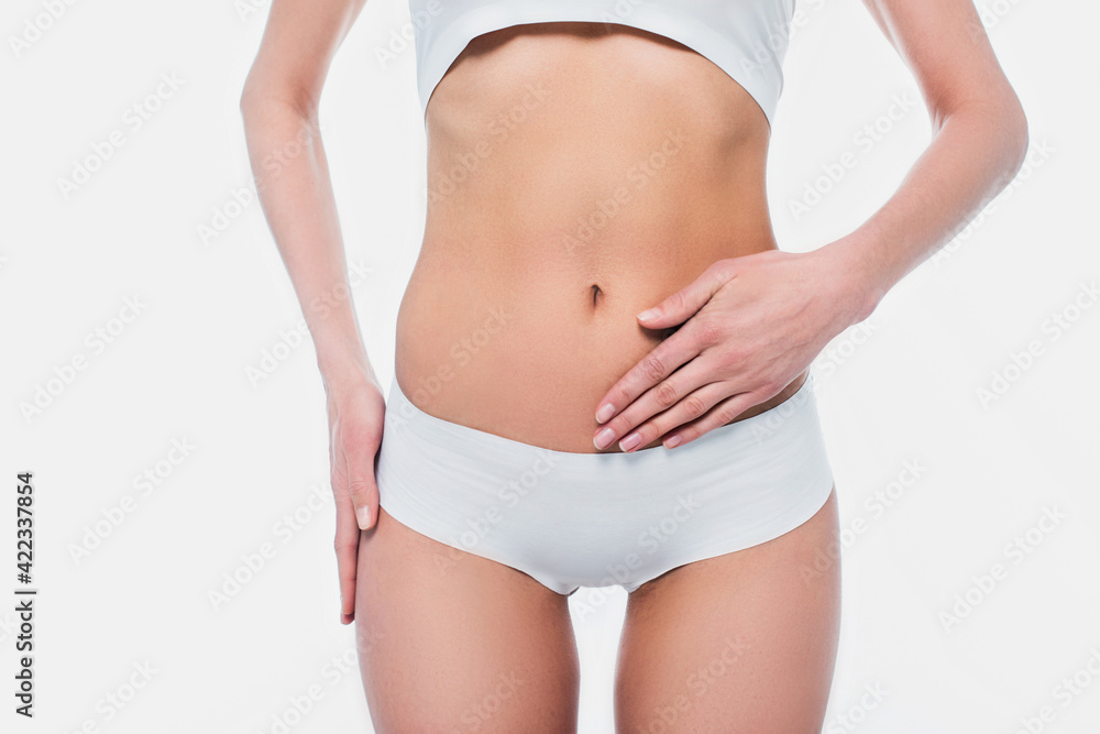Cropped view of woman in underwear touching belly isolated on white