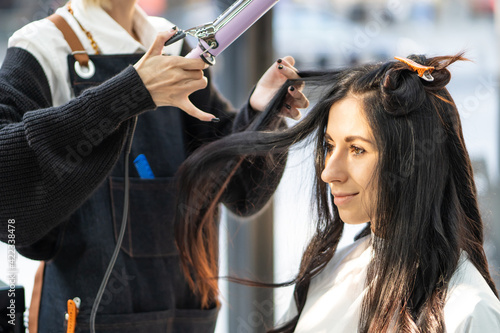 Caucasian women with Hair stylish while do hair cut and wearing surgical face mask while styling hair for client. Professional occupation, beauty and fashion service new normal