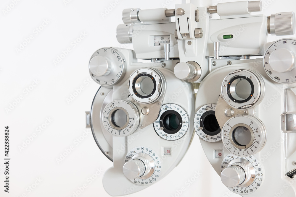 Selective focus at Optometry frame equipment. With blurred white background for copy space. Optometrist tool to examine eye visual system of patient with professional machine before made glasses. Selective focus at Optometry frame equipment. With blurred white background for copy space. Optometrist tool to examine eye visual system of patient with professional machine before made glasses.