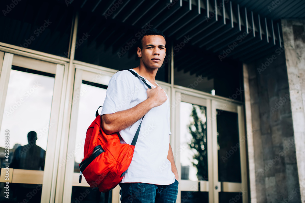 Pensive black man with backpack on street Pensive black man with backpack on street