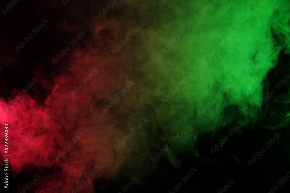 Smoke in red-green light on black background in darkness