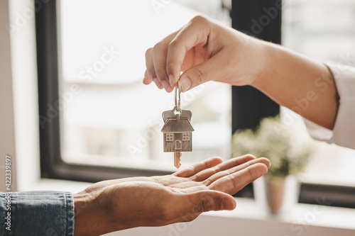 Close up hand of home,apartment agent or realtor was holding the key to the new landlord,tenant or rental.After the banker has approved and signed the purchase agreement successfully.Property concept. photo